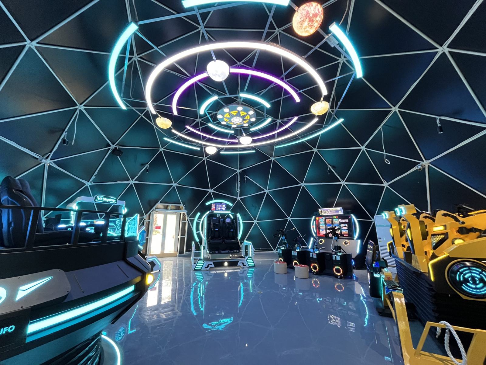 Bên trong dome 15 m làm khu trò chơi thực tế ảo: khung tam giác tối, vòng đèn LED trên trần