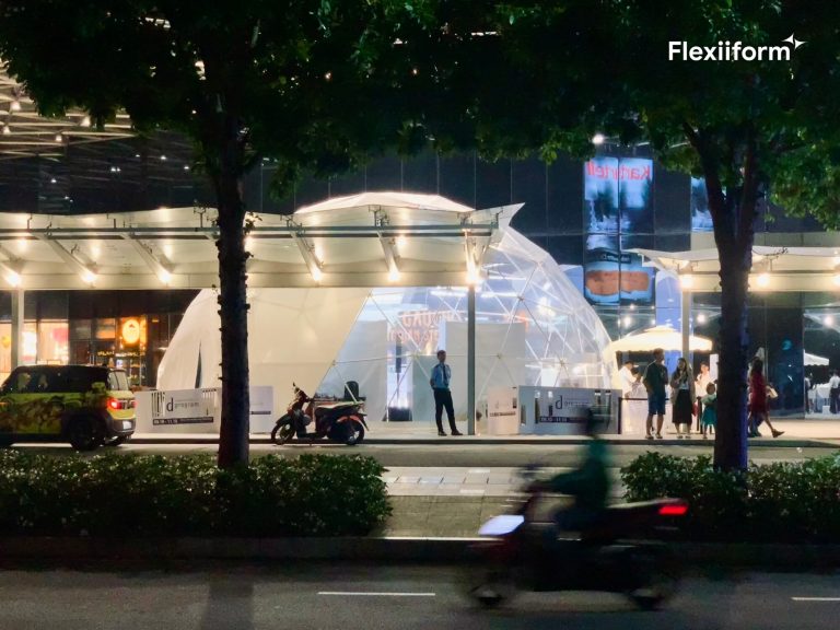 Dome trong suốt phát sáng sau hàng cây ven đường, khách đứng trước lối vào