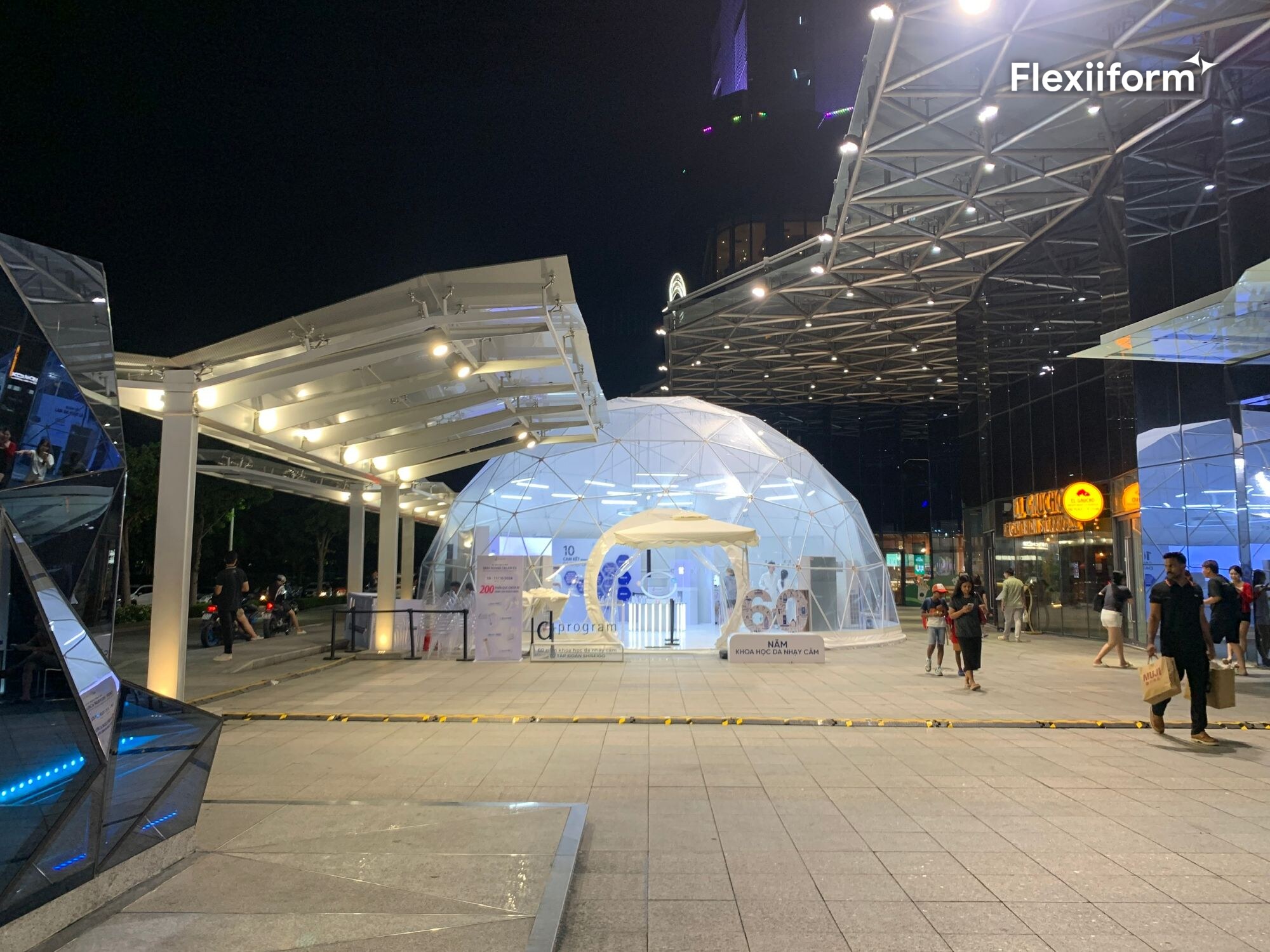 Dome trong suốt 12 m sáng đèn trên sân trung tâm thương mại về đêm, khách đứng trước cổng vòng tròn